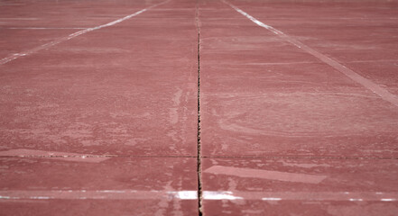 detail of some white and yellow lines painted on a brown sport court