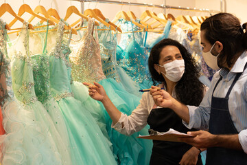 Professional brazilian colleagues with face mask checking product inventory inside business store. owner, small business, successful, community concept..