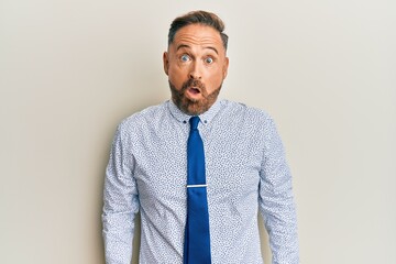 Handsome middle age man wearing business shirt and tie afraid and shocked with surprise expression, fear and excited face.