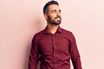 Young hispanic man wearing casual clothes looking to side, relax profile pose with natural face and confident smile.