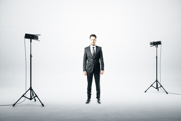 Businessman standing in studio with spotlight