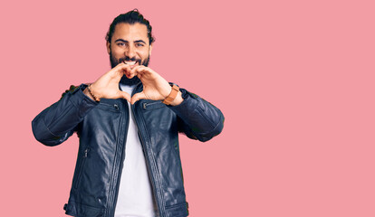 Fototapeta premium Young arab man wearing casual leather jacket smiling in love doing heart symbol shape with hands. romantic concept.