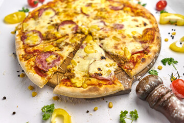 Delicious pizza with sausage, corn, minced meat on wooden plate
