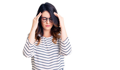 Beautiful young brunette woman wearing casual clothes and glasses with hand on head for pain in head because stress. suffering migraine.