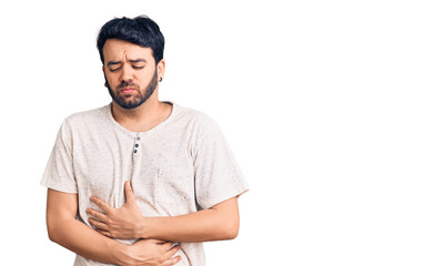Fototapeta premium Young hispanic man wearing casual clothes with hand on stomach because indigestion, painful illness feeling unwell. ache concept.
