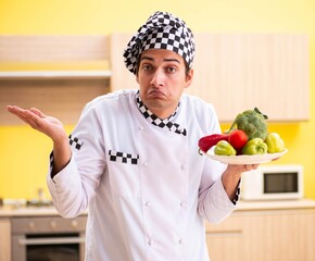 Young professional cook preparing salad at home