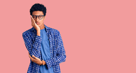 Young african american man wearing casual clothes and glasses thinking looking tired and bored with depression problems with crossed arms.