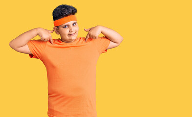Little boy kid wearing sportswear looking confident with smile on face, pointing oneself with...