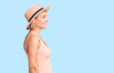Young blonde woman wearing summer hat looking to side, relax profile pose with natural face and confident smile.