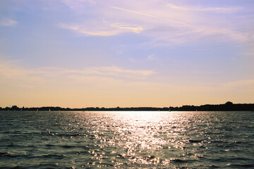 Calm lake in the sunshine with a cloudy sky