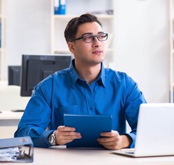 Handsome businessman employee sitting at his desk in office