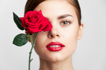 Woman with long Close-up of holding a rose near the face hairstyle red lips 