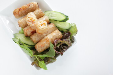 Vietnamese food, deep fried spring roll served with cucumber and salad