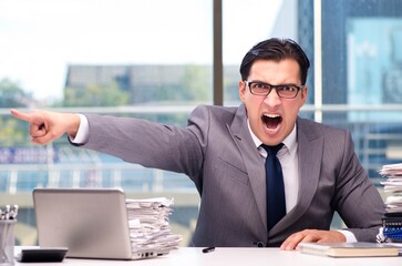 Angry businessman with too much work in office