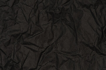 Crumpled black paper with wrinkles texture background. Dark design is blackboard. 