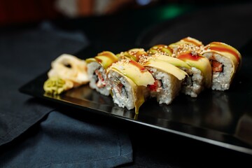 Golden dragon sushi roll with tuna, eel, cucumber, sesame seeds and tobiko caviar.
