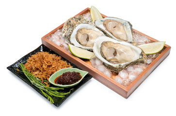 Fresh Oysters in a wood plate with chilli paste and lemon on white background,Thai style seafood.