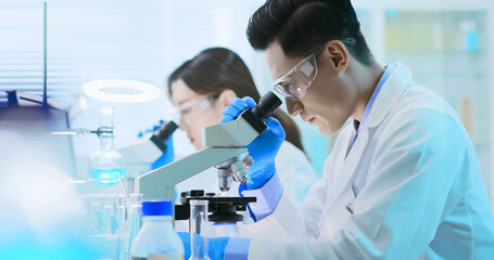 Asian scientist use microscope