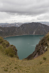 Naklejka premium detail of a lake between the mountains and a cloudy sky in Ecuador, Quilotoa