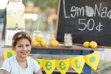 girl smiling selling lemonade in a nice weather 