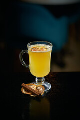 alcoholic cocktail yellow with lemon and cinnamon on a dark background in the bar