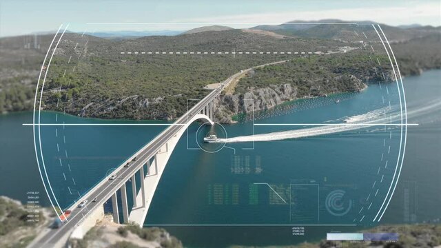 Aerial view of a traffic boat passing under a bridge with computerized animation of someone spying on it, through a tracking device installed on drone