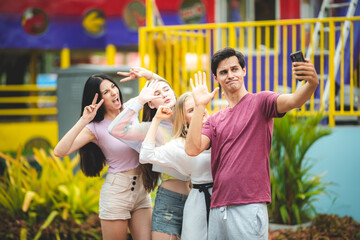 Naklejka premium Group of happy best friends laughing and taking selfie photo at amusement park, holiday travel with friends concept