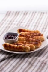 Merienda colombiana. pasteles horneados rellenos de queso con pasta crujiente. Comida para la tarde llamada deditos de queso con bebida de chocolate caliente.