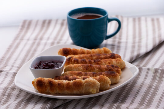 Merienda colombiana. pasteles horneados rellenos de queso con pasta crujiente. Comida para la tarde llamada deditos de queso con bebida de chocolate caliente.