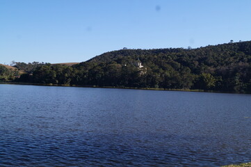 blue lake with a horizon of a forest in the mountains
