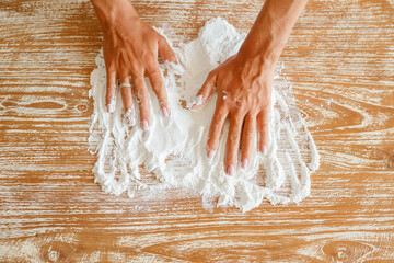 Woman hand prepare bread dough  white flour on dough for baking cookies in the kitchen