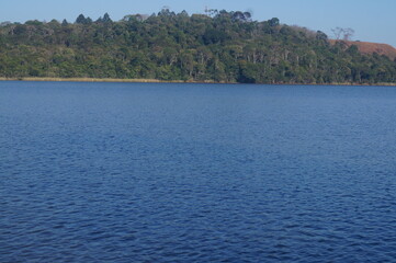 blue lake with a horizon of a forest in the mountains
