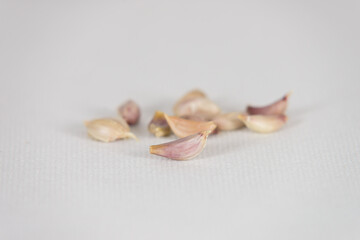 Fresh garlic cloves on white canvas background with copy space. select focus