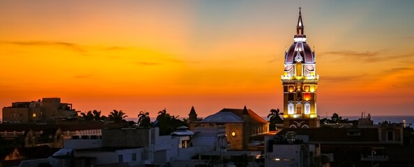 Wonderful view after sunset over Cartagena with illuminated Cartagena Cathedral against orange-yellow sky - obrazy, fototapety, plakaty