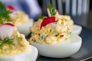 freshly prepared boiled eggs filled with mayo, onions, egg and radish garnished with dill.