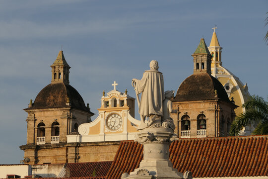Close up view over roofs in Cartagena with statue and bell towers of church San Pedro Claver
