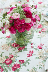 Pretty spring flower bouquet on a glass vase on colorful tablecloth