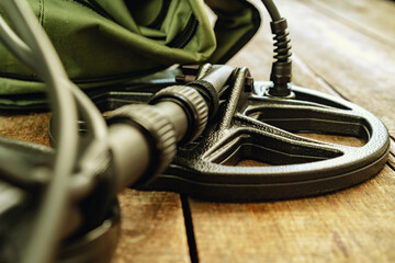 Metal detector tool on wooden board close up