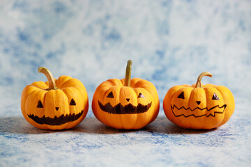Halloween pumpkins with painted face on blue color background