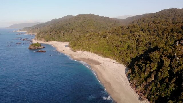 Picturesque Scenery Of The Monro Beach In The West Coast Of New Zealand. Verdant Forest Along The Shoreline With Dark Blue Sea - aerial drone