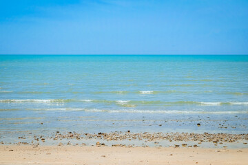 Beautiful wave with blue sky over the horizon on the beach background. Tropical colorful sand from the landscape sea. The holiday summer vacation concept.