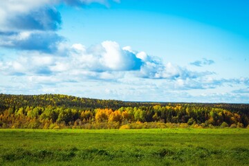 Beautiful autumn landscape with colorful forest taiga and sky with clouds
