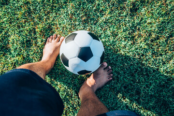 Above view of foot man playing classic leather soccer ball on grass field in the arena stadium....