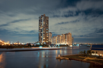 Fantastic night time skyline with high rise apartment building by the Chao Praya river in Bangkok city, Thailand.
