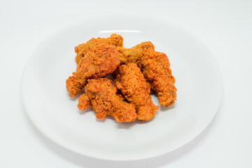 Hot fried chicken leg spicy in plate on white background. Delicious southern Kentucky drumstick crunchy meal. Recipe fast food pieces.