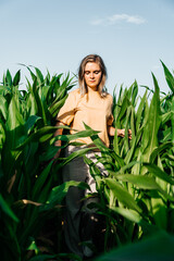 young woman in a corn field in a yellow t-shirt with a place under the text with short hair