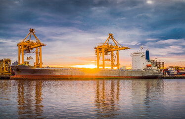 Harbor with anchored ship. Container cargo freight ship with working crane bridge at a shipyard in for logistic transportation import and export at Asia haven port background, Samutprakarn, Thailand.