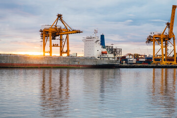 Harbor with anchored ship. Container cargo freight ship with working crane bridge at a shipyard in for logistic transportation import and export at Asia haven port background, Samutprakarn, Thailand.