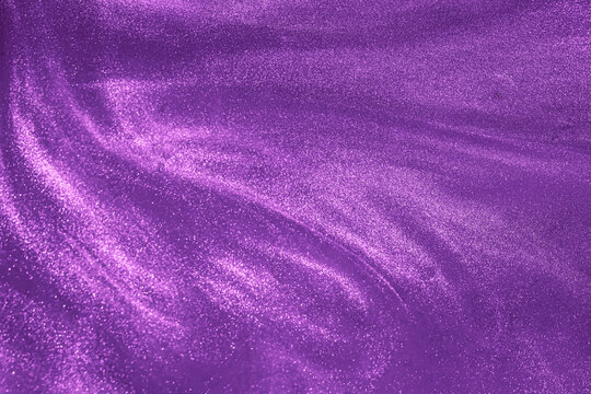 de-focused. Abstract elegant, detailed purple glitter particles flow underwater. Holiday magic shimmering luxury background. Festive sparkles and lights.