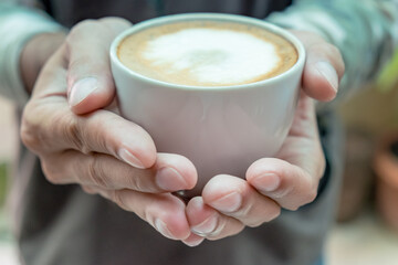 Front view of young man holding hot coffee cup the best start to any morning at the cafe.